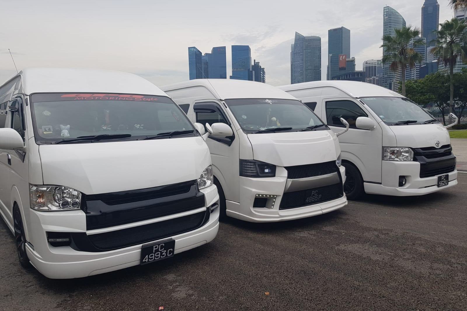Three SKO maxi cabs lined up against the Singapore skyline